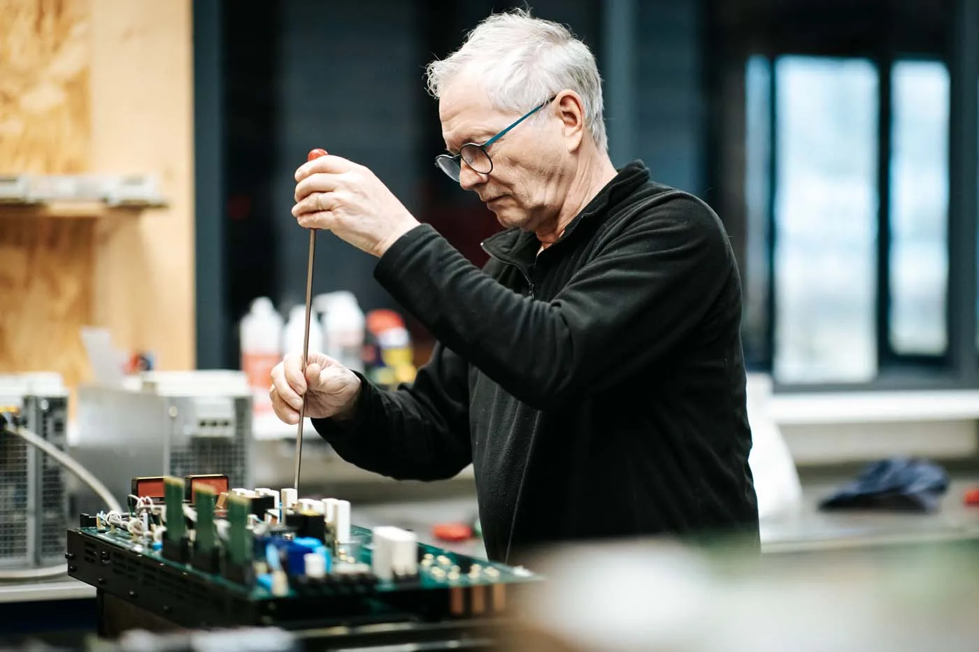 Technicien réparant une carte électronique en atelier